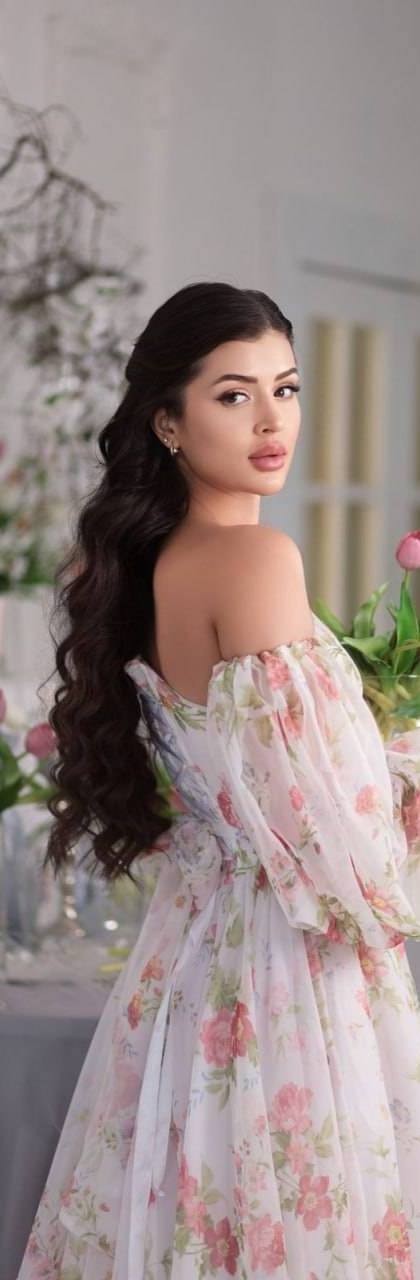 beautiful brunette woman in elegant floral off shoulder dress holding pink tulips, luxury bright interior with spring flowers, soft natural light, feminine portrait photography