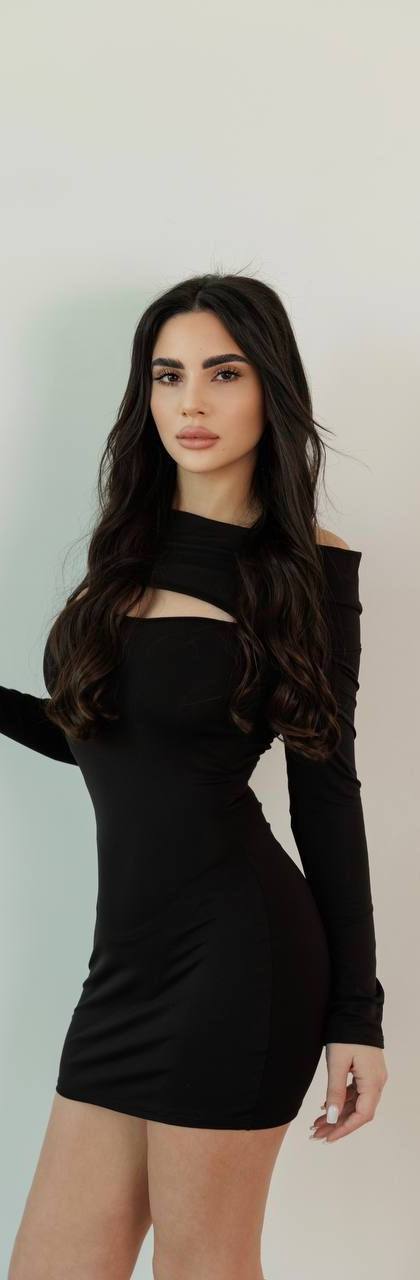 Elegant luxury escort model wearing a fitted black mini dress during a professional studio photoshoot